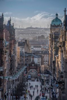 a city street filled with lots of traffic and people walking on the side of it