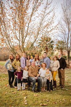 a group of people standing next to each other in front of a tree