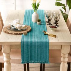 the table is set with two place settings and silverware, along with a blue runner