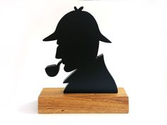 the silhouette of a man with a pipe in his mouth is on a wooden stand