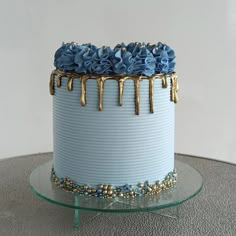 a frosted cake with blue icing and flowers on top