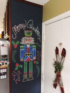 a chalk board with a christmas nutcracker painted on it's front door