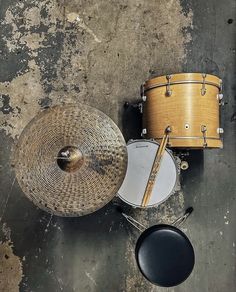 an overhead view of a drum and cyl set on a concrete floor with paint peeling off the wall