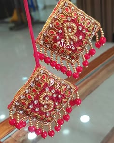 two red and gold ornaments hanging from a window