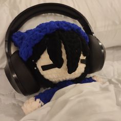 a stuffed animal wearing headphones on top of a bed