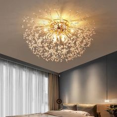 a bed room with a neatly made bed and a chandelier hanging from the ceiling