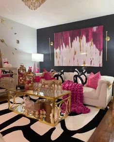 a living room filled with lots of furniture and pink pillows on top of a black and white rug