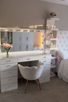 a white chair sitting in front of a desk with a mirror on top of it