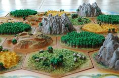 a close up of a game board with mountains and trees