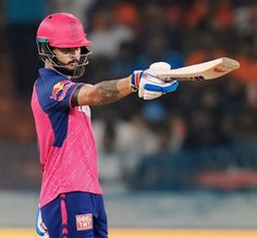 a man with a pink helmet holding a cricket bat