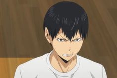 an anime character with black hair and white shirt looking at something in his hand while standing on a wooden floor