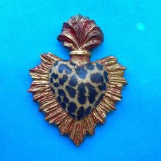 a blue and gold heart shaped brooch on a blue background