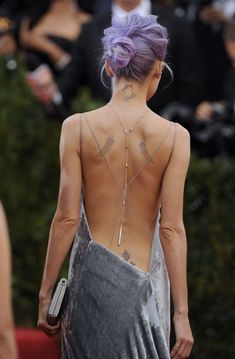 the back of a woman's dress with tattoos on it