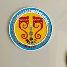 a yellow and blue plate sitting on top of a white table next to a clock