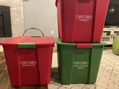 two red and green christmas bins sitting next to each other