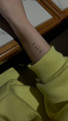 a person with a small tattoo on their left arm and the word love is written in black ink