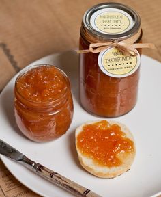 two jars of jam sit on a white plate