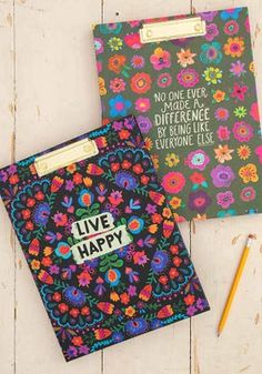 two notebooks with the words live happy written on them next to a pencil and eraser