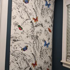 a bathroom with blue walls and butterflies on the wall next to the toilet seat cover