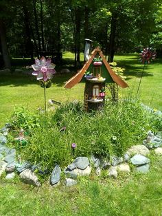 there is a small house in the middle of some rocks and grass with flowers growing out of it