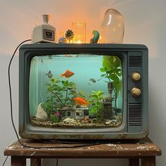 an old tv with fish in it sitting on top of a table