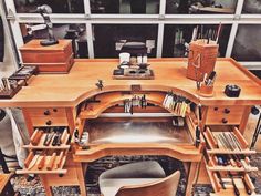 a wooden workbench with tools and other items sitting on the table in front of a window