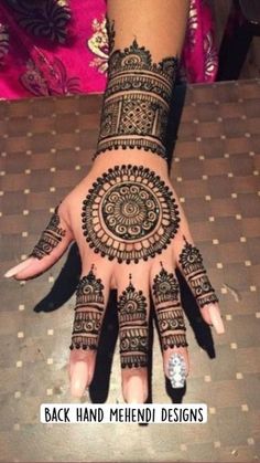 a woman's hand decorated with henna and intricate designs on her hands,