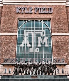 the front of a building that has a sign on it and some statues in front