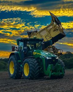 a tractor with a large load on it's back in the middle of a field