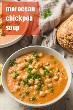 two bowls of chickpea soup with bread and lemon wedges on the side