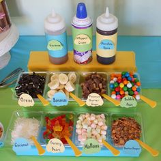 an assortment of food items displayed in plastic containers on a green tableclothed surface