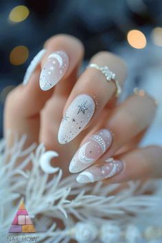 Elevate your nail game with these ethereal celestial nails. The delicate white and silver star patterns against a sheer background offer a dreamy look that's both subtle and striking. Discover more nail inspo at nailhow.com. Fancy Simple Nails, Space Themed Nails Acrylic, Summer Celestial Nails, Simple Celestial Nails, Celestial Wedding Nails, White Celestial Nails, White Nail Polish Ideas, Night Court Nails, Acotar Nails