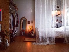 a bedroom with wooden floors and white curtains