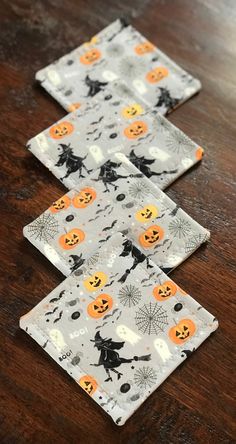 three halloween napkins sitting on top of a wooden table