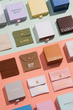 many different types of business cards and wallets on a pink table with pastel colors