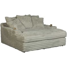 a large white couch with lots of pillows on it's back and side ends