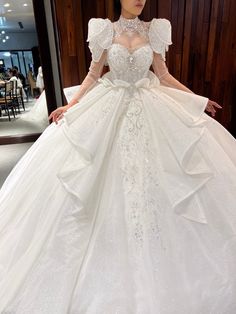 a woman in a white wedding dress is posing for the camera