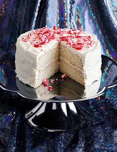 a cake with white frosting and red sprinkles is cut in half