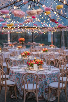 an outdoor tent with tables and chairs set up under umbrellas for a wedding reception