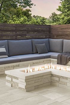 a fire pit sitting on top of a patio next to a wooden fence