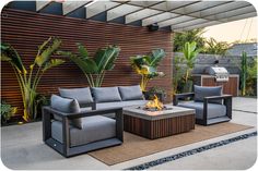 an outdoor living area with couches and fire pit