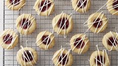 cookies with white icing and raspberry toppings on a wire cooling rack