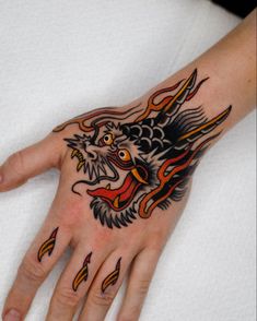 a person's hand with a dragon tattoo on it