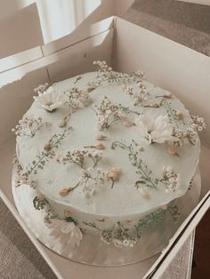 a white cake in a box with flowers on it