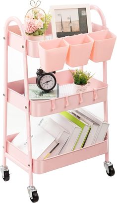 a pink cart with books, magazines and a clock