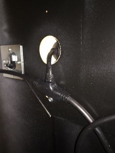 an electrical outlet is plugged in to the side of a black wall with wires running through it