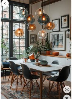 a dining room table surrounded by hanging lights