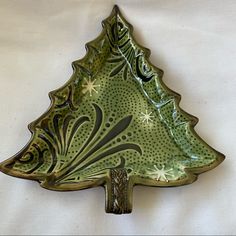 a green ceramic christmas tree dish on a white background