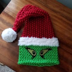 a green and red knitted hat with eyes