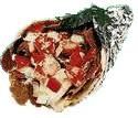 a sandwich wrapped in tin foil with toppings